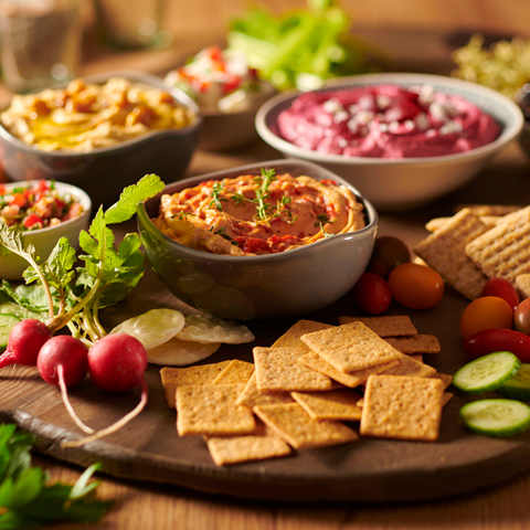 Dip platter arranged for a party with vegetables and bowls of dip